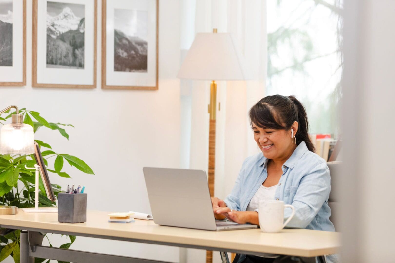 Smiling woman working on a laptop.